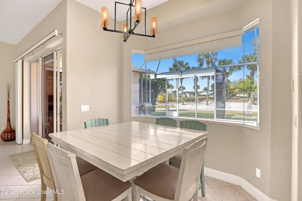 a dining room with stainless steel appliances a table and chairs