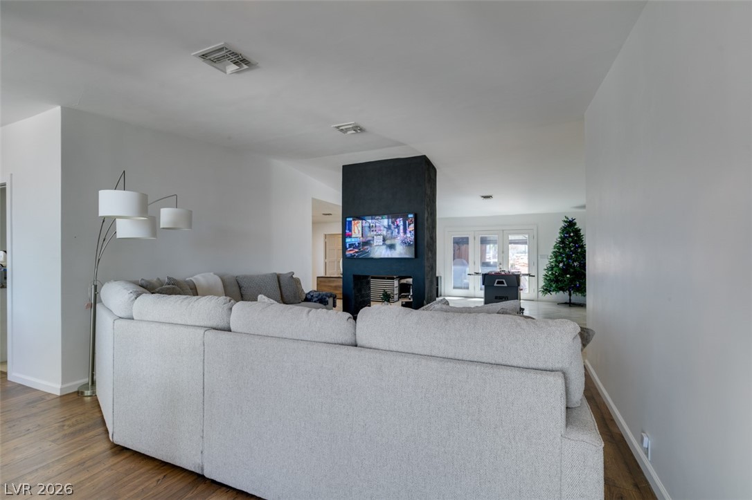 892 North Hollywood Boulevard Las Vegas, NV 89110 - Photo 21 of 81 This inviting living room features warm wood flooring and a modern fireplace, perfect for relaxing evenings.