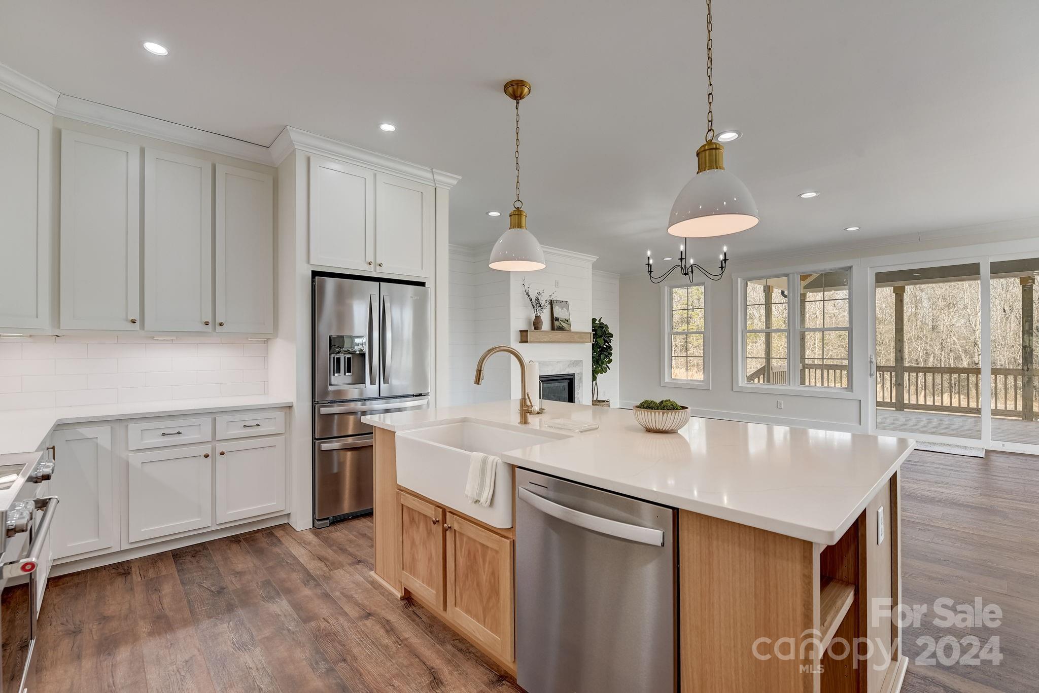 315 Cal Kennedy Road Cleveland, NC 27013 - Photo 14 of 39 a kitchen with stainless steel appliances granite countertop a sink a stove a refrigerator and island with wooden floor
