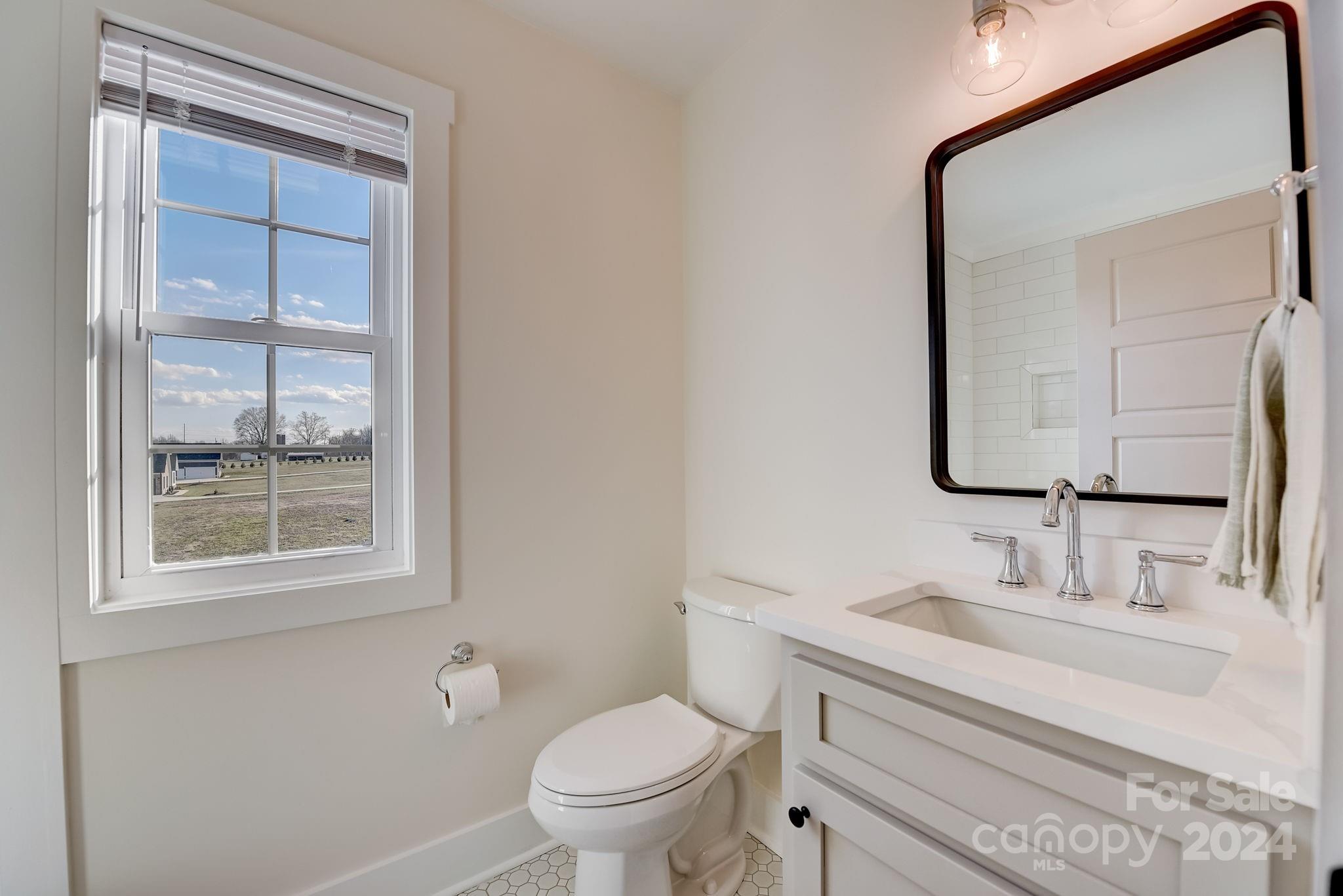 315 Cal Kennedy Road Cleveland, NC 27013 - Photo 29 of 39 a bathroom with a toilet sink vanity and mirror