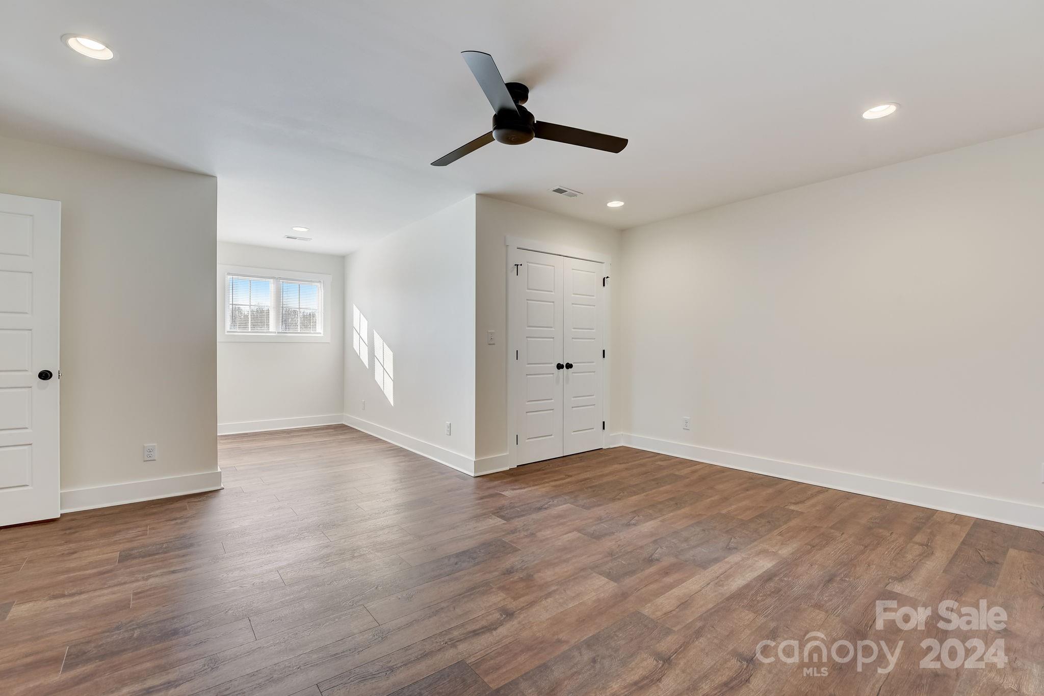 315 Cal Kennedy Road Cleveland, NC 27013 - Photo 30 of 39 an empty room with wooden floor ceiling fan and windows