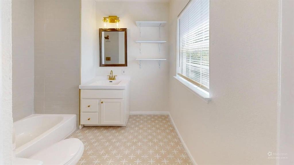 2012 Tennessee Avenue Dallas, TX 75224 - Photo 13 of 19 a bathroom with a toilet sink and mirror