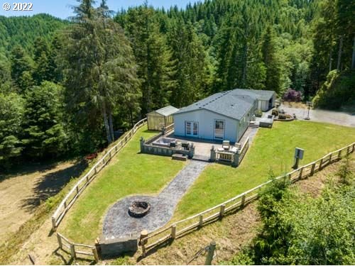 an aerial view of a house with swimming pool and large trees