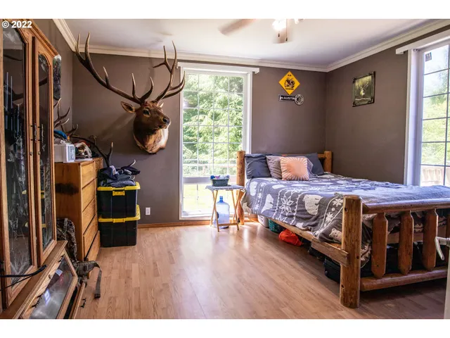 a bedroom with a bed a flat screen tv and a window