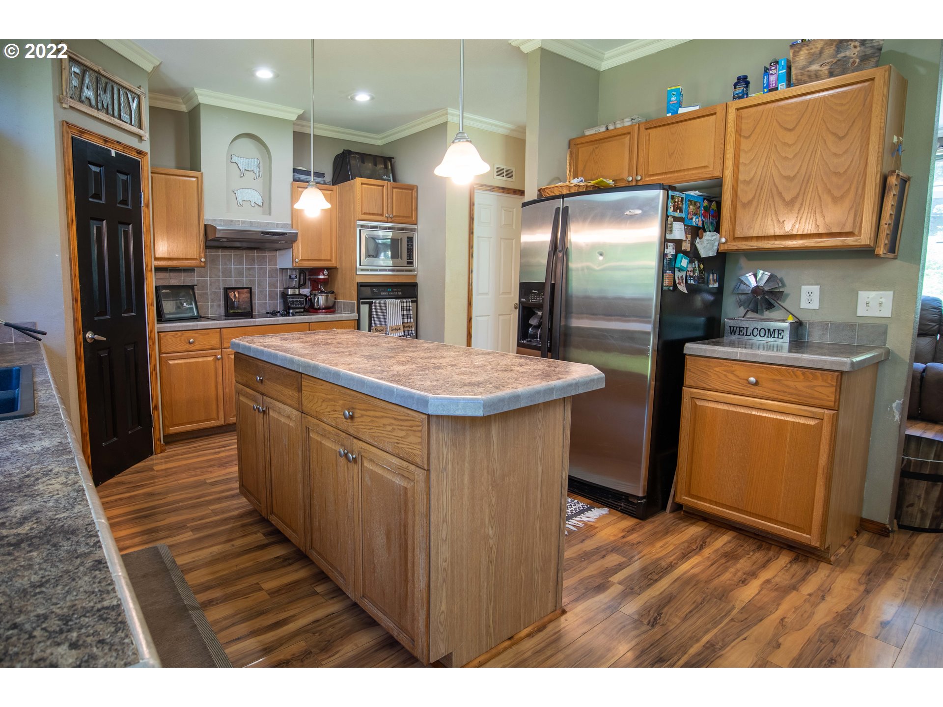 1578 Scholfield Road Reedsport, OR 97467 - Photo 9 of 37 a kitchen with stainless steel appliances a refrigerator and wooden floor