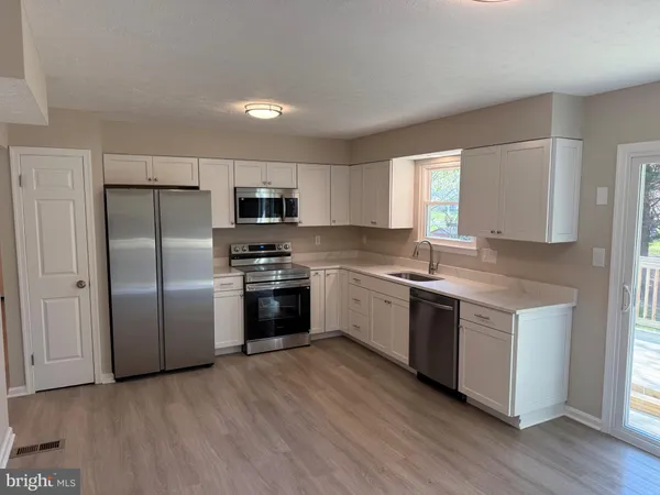 a kitchen with stainless steel appliances and wooden cabinets