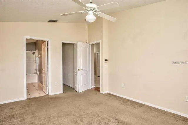 a view of a room with a ceiling fan and a bathroom