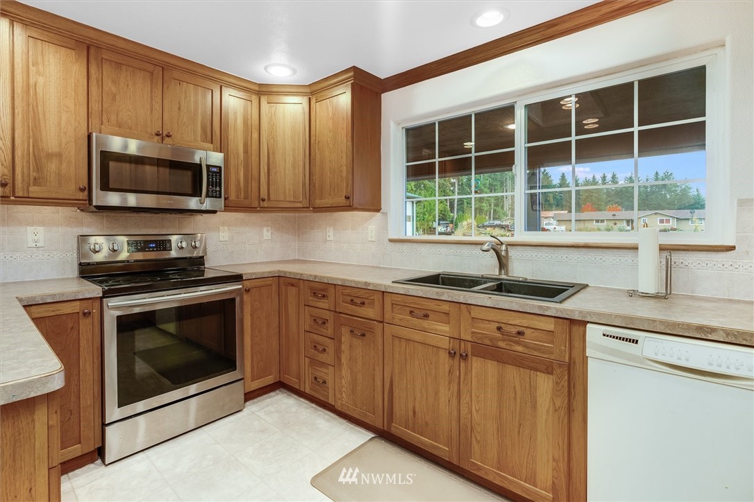 454 Harmon Road, Unit 26 Chehalis, WA 98532 - Photo 11 of 35 a kitchen with stainless steel appliances granite countertop a sink a stove a microwave and wooden cabinets