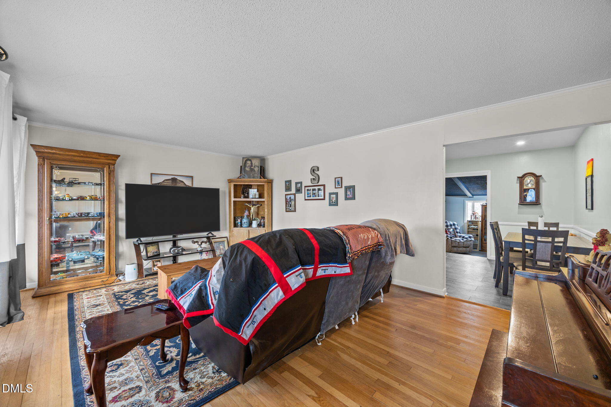 317 Clapp Street Graham, NC 27253 - Photo 5 of 33 a living room with furniture and a flat screen tv with wooden floor