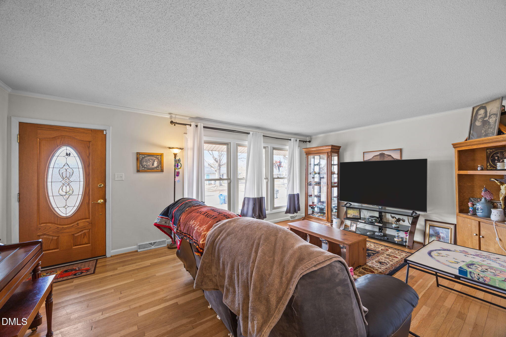 317 Clapp Street Graham, NC 27253 - Photo 6 of 33 a living room with furniture a clock on the wall and a large window
