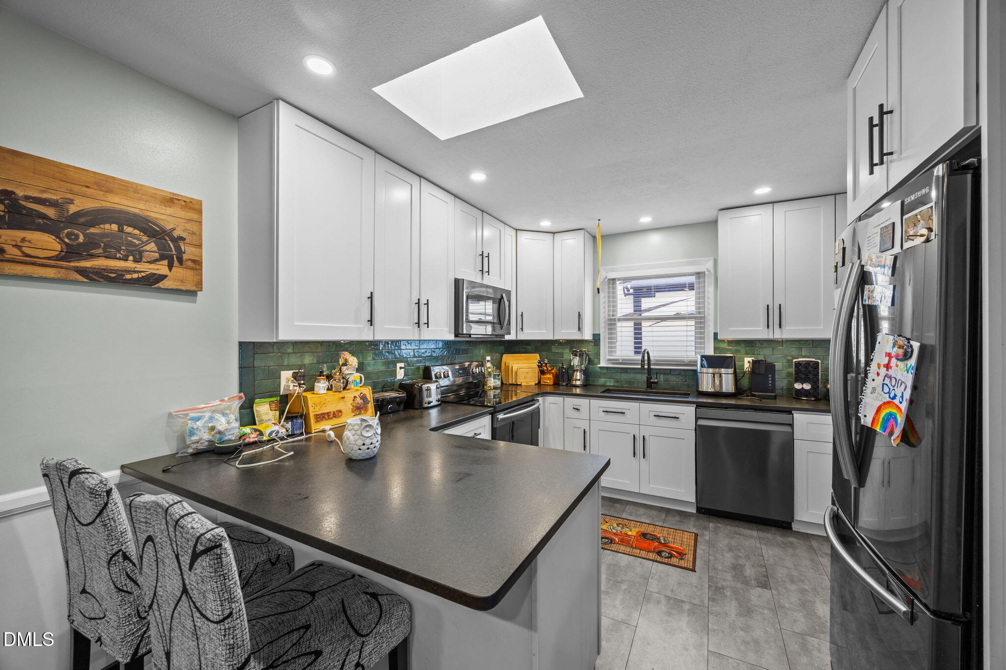 317 Clapp Street Graham, NC 27253 - Photo 9 of 33 a kitchen with stainless steel appliances granite countertop a sink refrigerator and cabinets