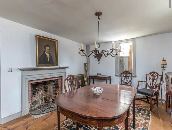 a view of a livingroom and dining room with furniture wooden floor a chandelier