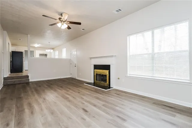 an empty room with windows and fireplace