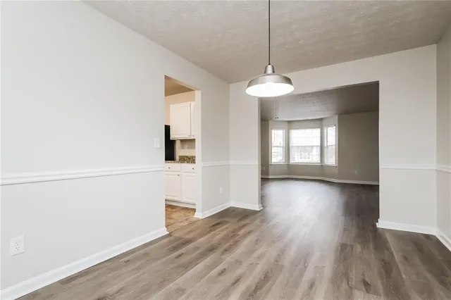 a view of a room with wooden floor fireplace and windows