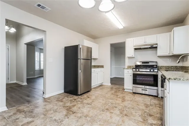 a kitchen with a refrigerator and a stove