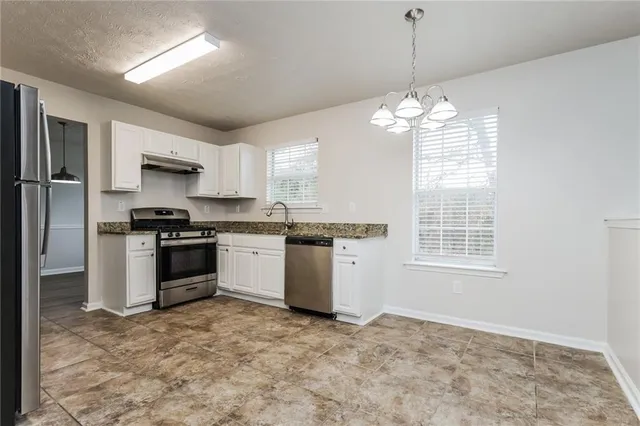 a kitchen with granite countertop a stove and a refrigerator