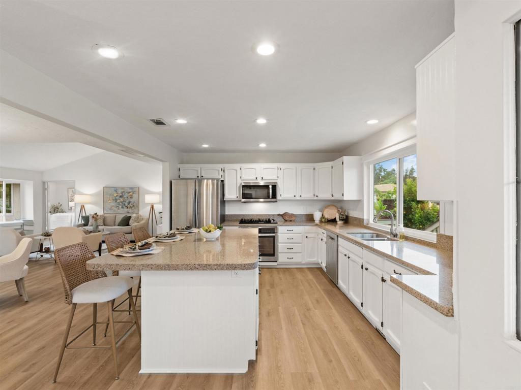 13737 Temple Street Poway, CA 92064 - Photo 11 of 38 a kitchen with stainless steel appliances kitchen island granite countertop a sink and cabinets