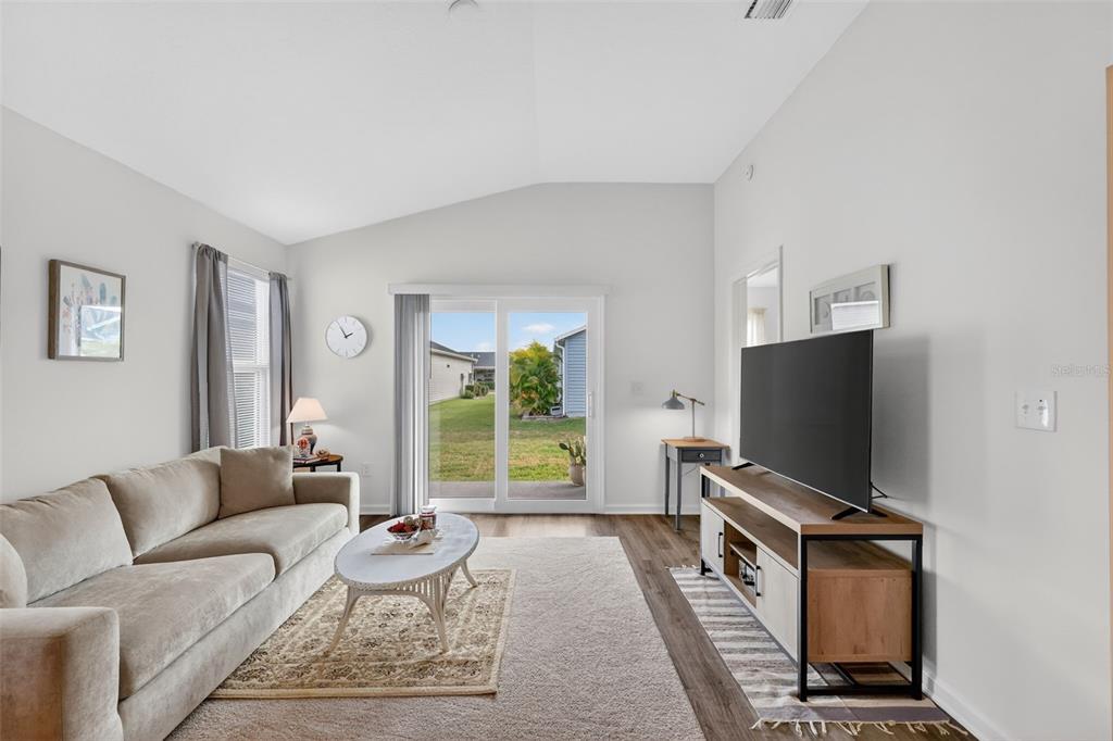 832 Conroe Street The Villages, FL 34762 - Photo 13 of 37 a living room with furniture a window and a flat screen tv