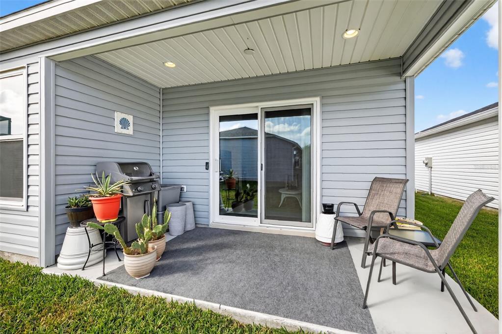 832 Conroe Street The Villages, FL 34762 - Photo 26 of 37 a view of a patio with table and chairs and potted plants