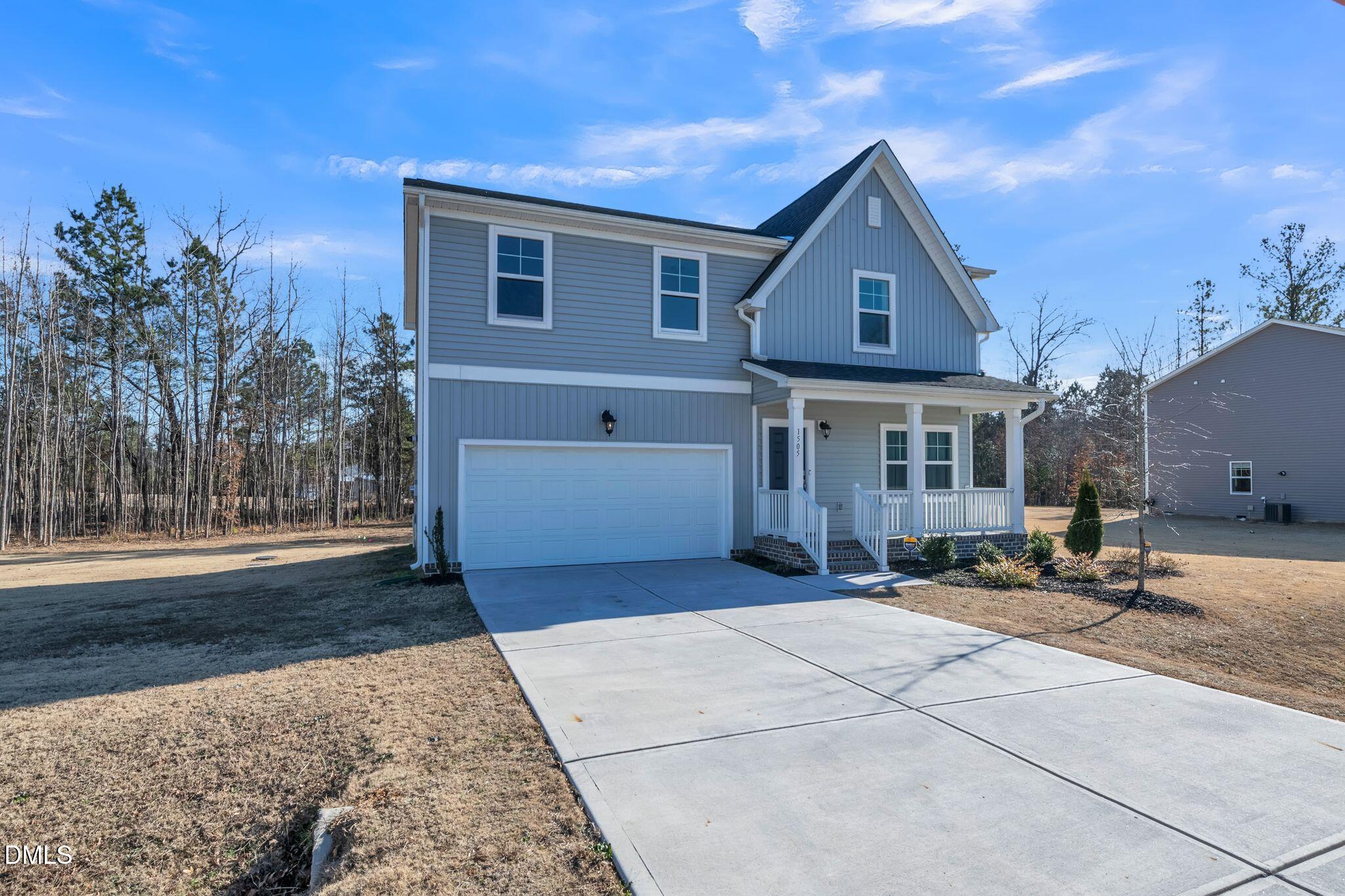 a front view of house with yard and trees in the background