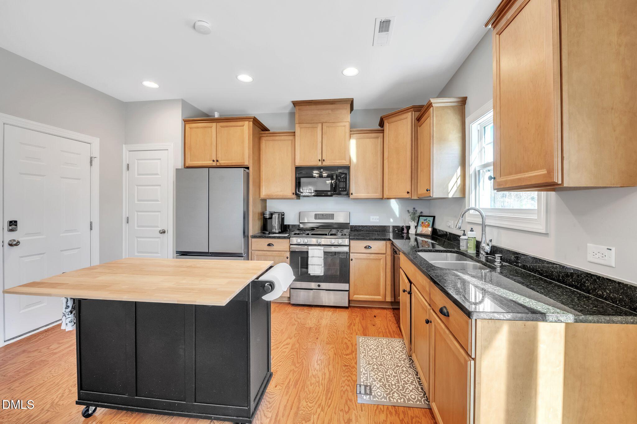 1505 Tawny View Lane Raleigh, NC 27603 - Photo 4 of 15 a kitchen with stainless steel appliances granite countertop a refrigerator a sink dishwasher a stove and white countertops with wooden floor