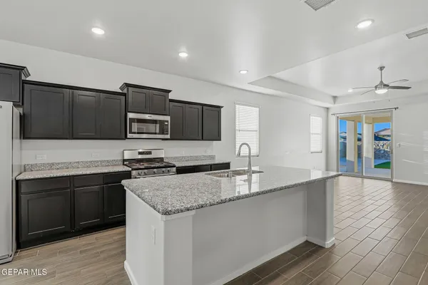 a kitchen with stainless steel appliances granite countertop a sink and a microwave