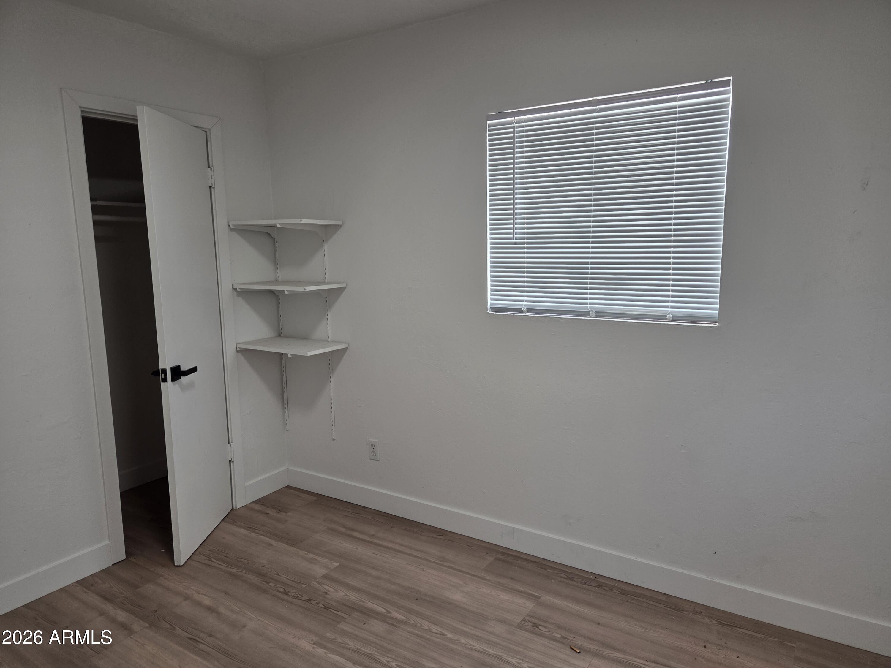 2201 East Portland Street Phoenix, AZ 85006 - Photo 11 of 11 a view of an empty room with wooden floor and a window