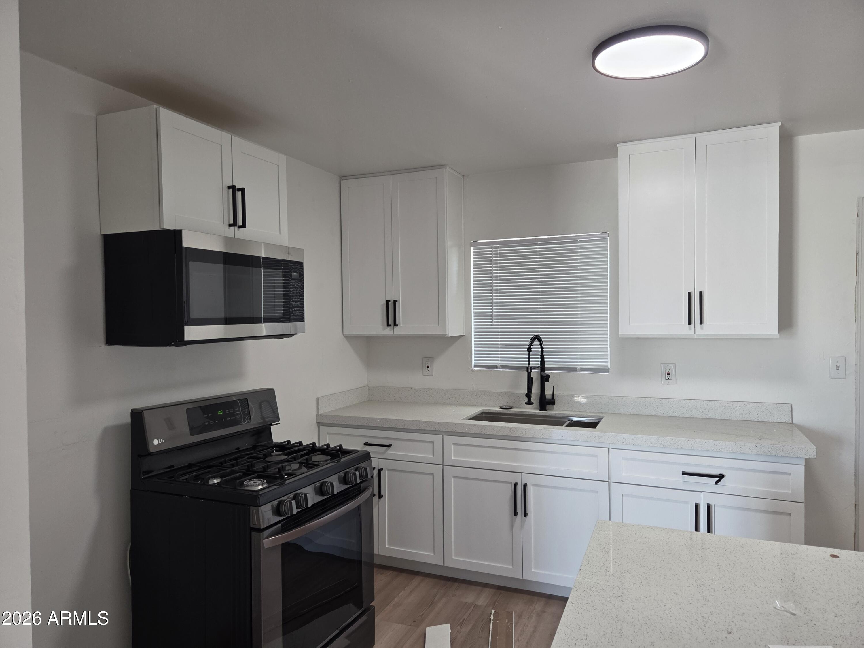 2201 East Portland Street Phoenix, AZ 85006 - Photo 7 of 11 a kitchen with a sink stove and microwave