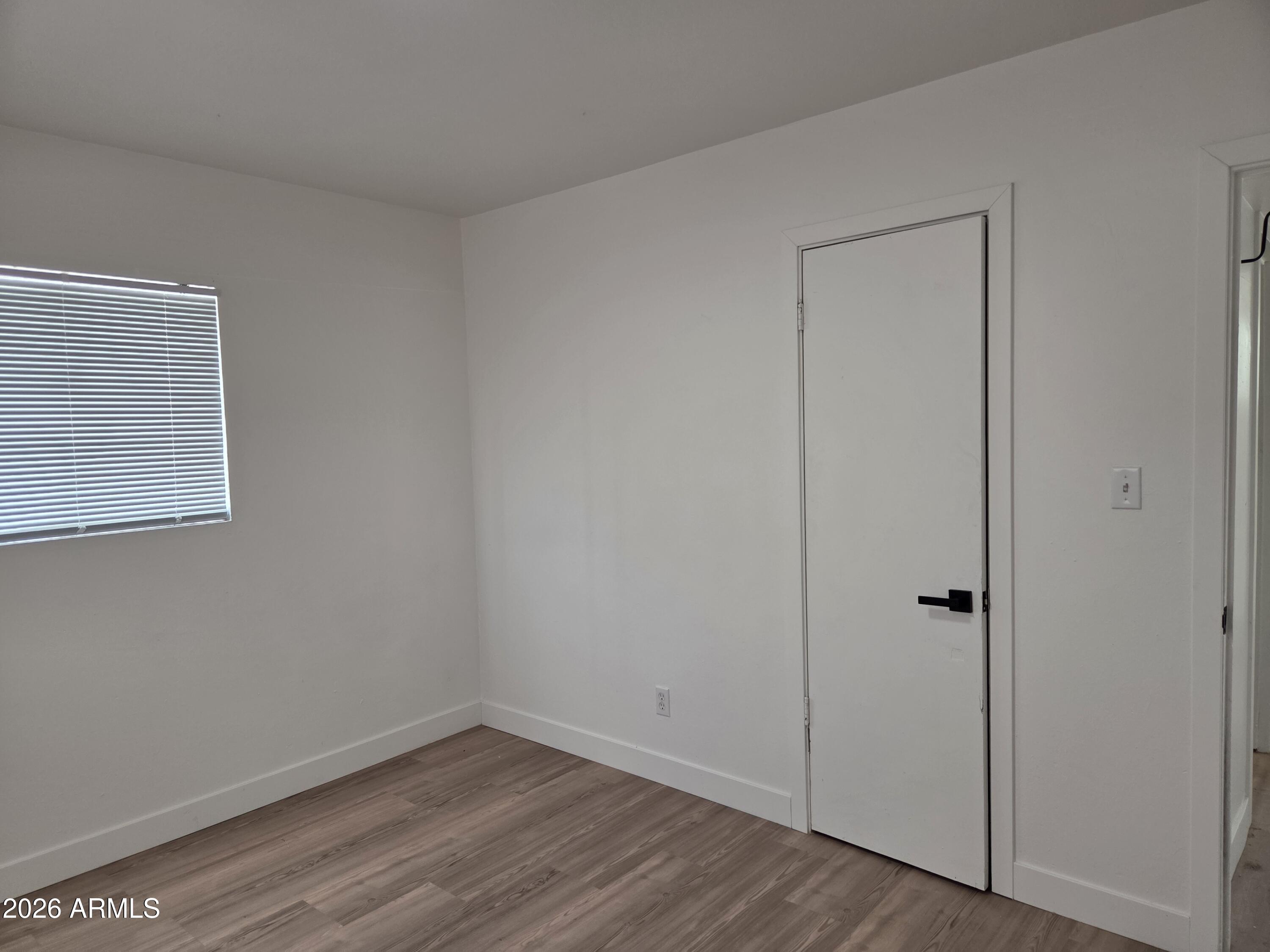 2201 East Portland Street Phoenix, AZ 85006 - Photo 9 of 11 an empty room with wooden floor and closet