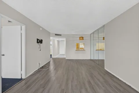 a view of a livingroom with wooden floor and windows