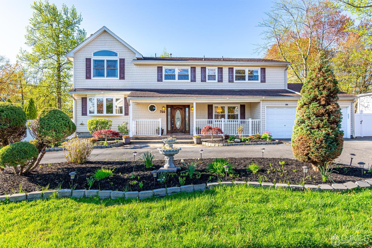 799 New Dover Road Edison, NJ 08820 - Photo 1 of 54 a front view of a house with a yard table and chairs