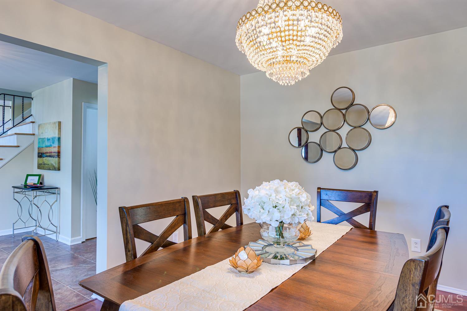 799 New Dover Road Edison, NJ 08820 - Photo 13 of 54 a view of a dining room with furniture a chandelier and wooden floor