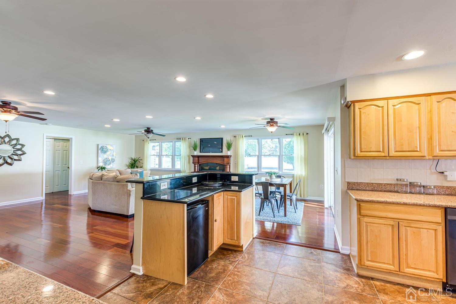 799 New Dover Road Edison, NJ 08820 - Photo 22 of 54 a kitchen with stainless steel appliances granite countertop a stove top oven a sink a dining table and chairs with wooden floor