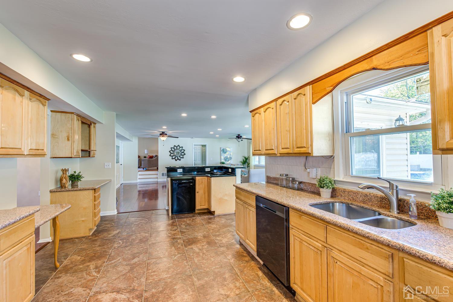 799 New Dover Road Edison, NJ 08820 - Photo 25 of 54 a large kitchen with kitchen island a sink a counter top space and stainless steel appliances