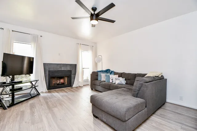 a living room with furniture a fireplace and a flat screen tv