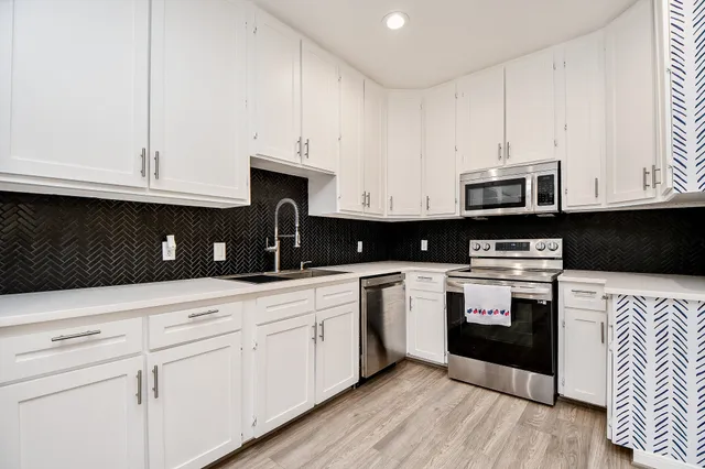a kitchen with cabinets stainless steel appliances and a counter space
