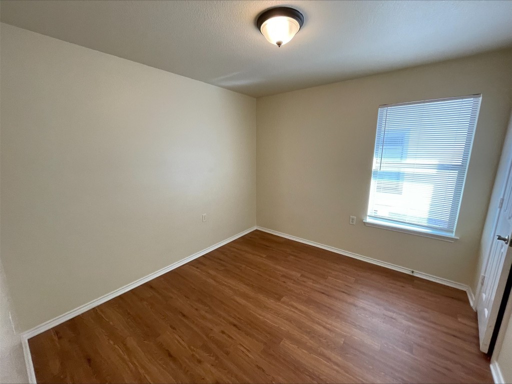 6912 Quinton Drive Austin, TX 78747 - Photo 17 of 24 an empty room with wooden floor and windows