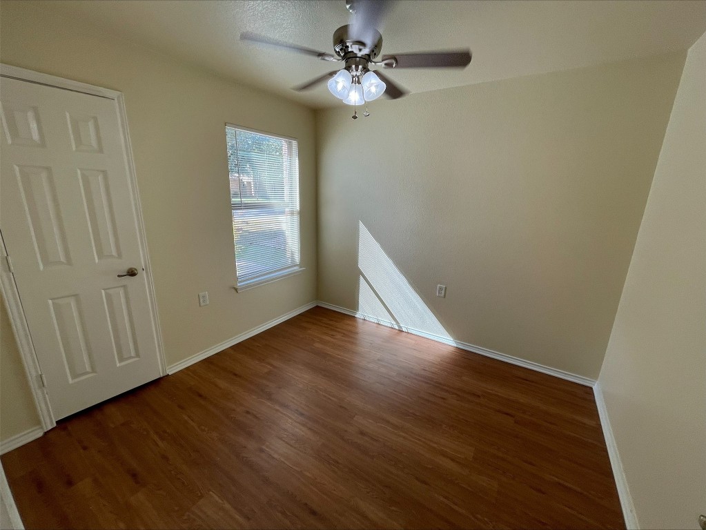 6912 Quinton Drive Austin, TX 78747 - Photo 21 of 24 an empty room with wooden floor chandelier fan and windows