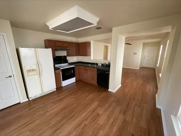 a kitchen with wooden floors and stainless steel appliances