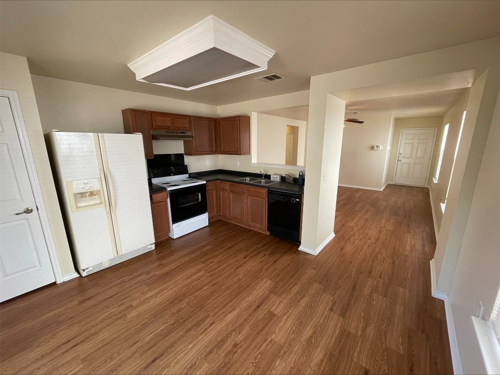 6912 Quinton Drive Austin, TX 78747 - Photo 22 of 24 a kitchen with wooden floors and stainless steel appliances
