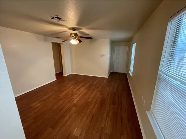 a view of empty room with wooden floor