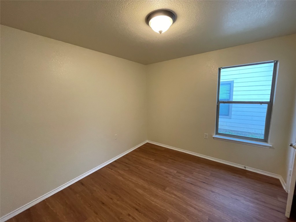 6912 Quinton Drive Austin, TX 78747 - Photo 9 of 24 an empty room with wooden floor and windows