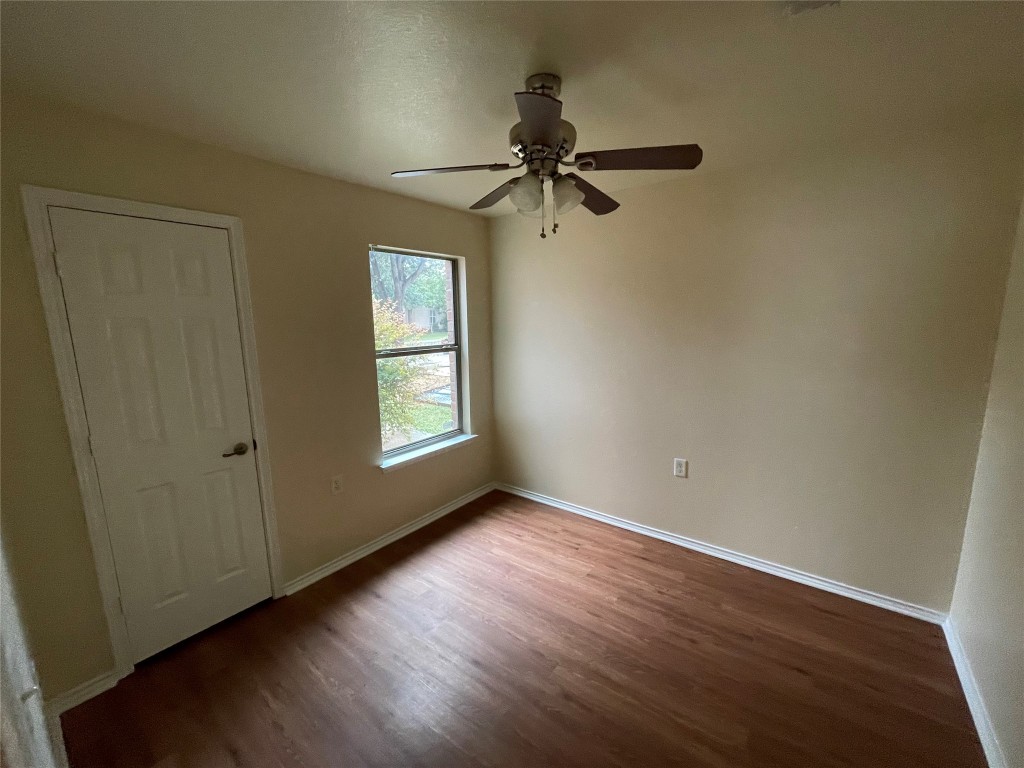 6912 Quinton Drive Austin, TX 78747 - Photo 10 of 24 an empty room with wooden floor cabinet and windows
