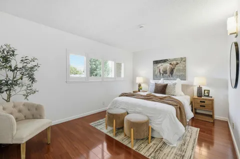 a bedroom with a bed and wooden floor