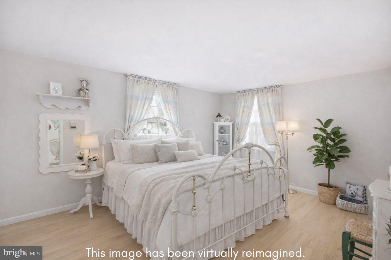 8406 Geneva Mason Road Potomac, MD 20854 - Photo 17 of 34 a bedroom with a large bed and a potted plant