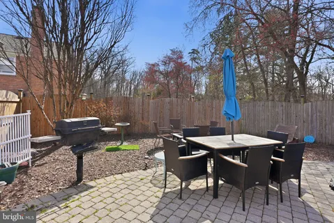 a view of a patio with table and chairs and couches with wooden fence and plants