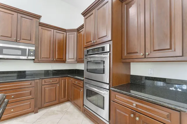 a kitchen with granite countertop stainless steel appliances a stove a microwave and cabinets