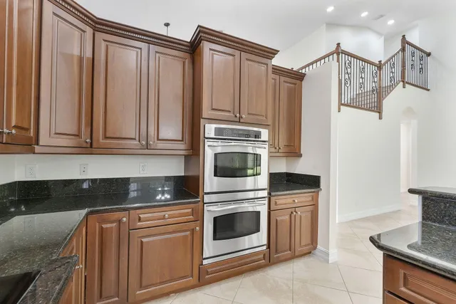 a kitchen with granite countertop white cabinets and stainless steel appliances