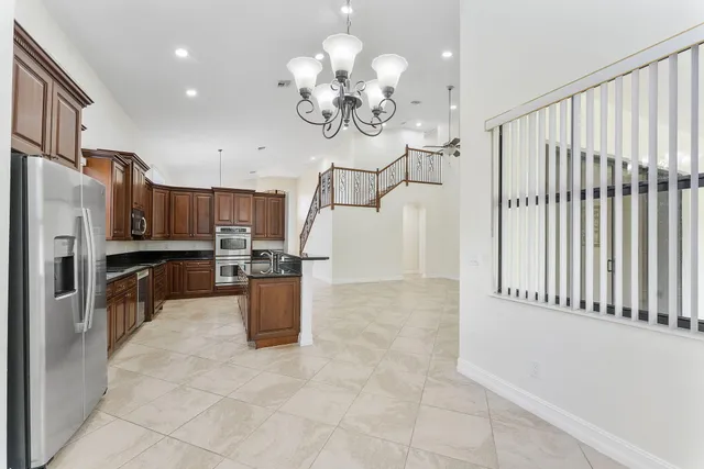 a kitchen with stainless steel appliances granite countertop a refrigerator and a sink