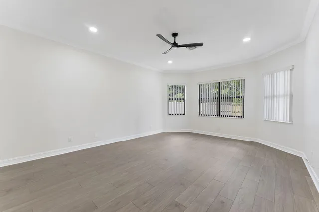 a view of an empty room with a window and wooden floor